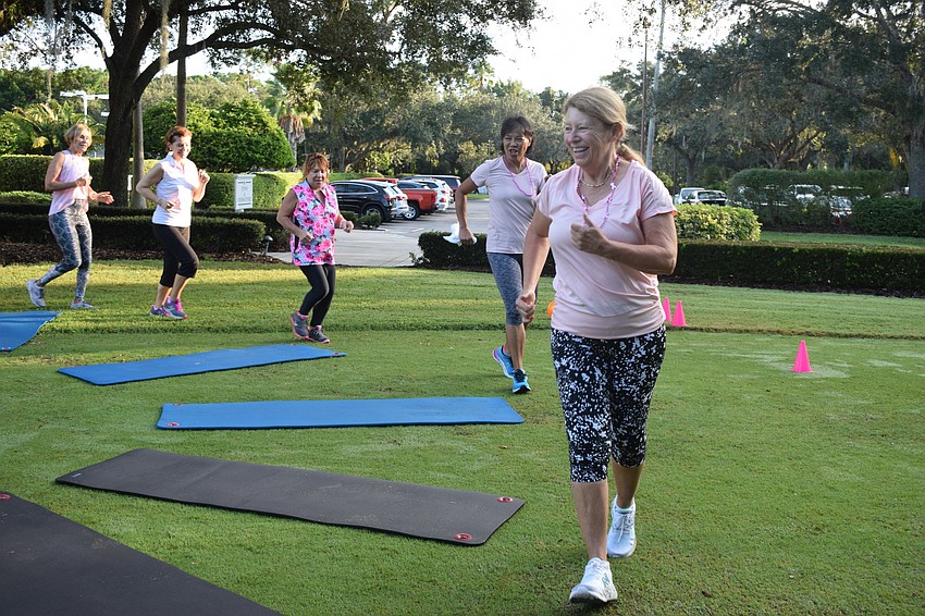 Pat Kempl runs around a circle of mats as music plays waiting until the music stops so she can get on a mat in musical squats.