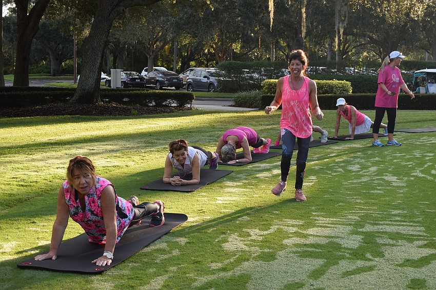Pam Glazer and her teammates continue doing planks as Gwen Murphy runs to the front in the plank relay.