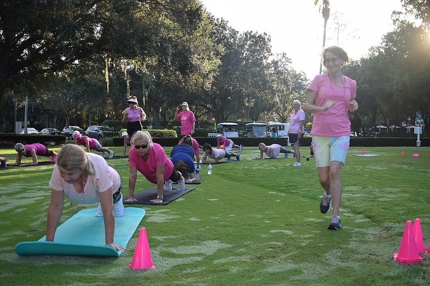 Annie Walsh does a plank alongside her teammates as Ellie Pinansky runs to the front of the line in a plank relay race.