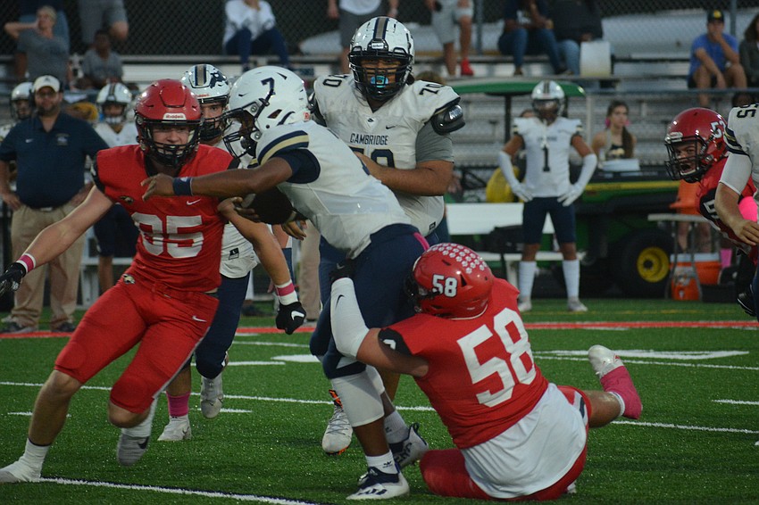 Sophomore Reece Dentici (58) makes a stop on Cambridge Christian quarterback Chris Stephenson.