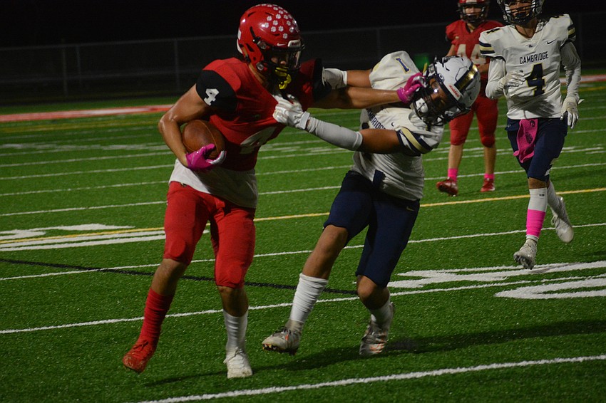 Mooney freshman wide receiver Ryan Matulevich stiff arms a defender.