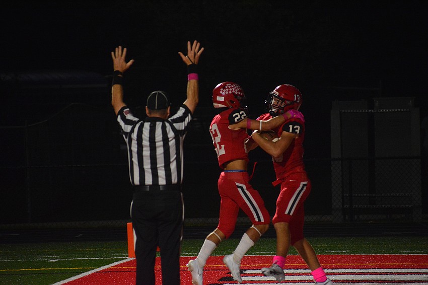 Sophomore Carson Beach (22) celebrates with junior tight end Thomas Matt (13) after Matt's touchdown catch.