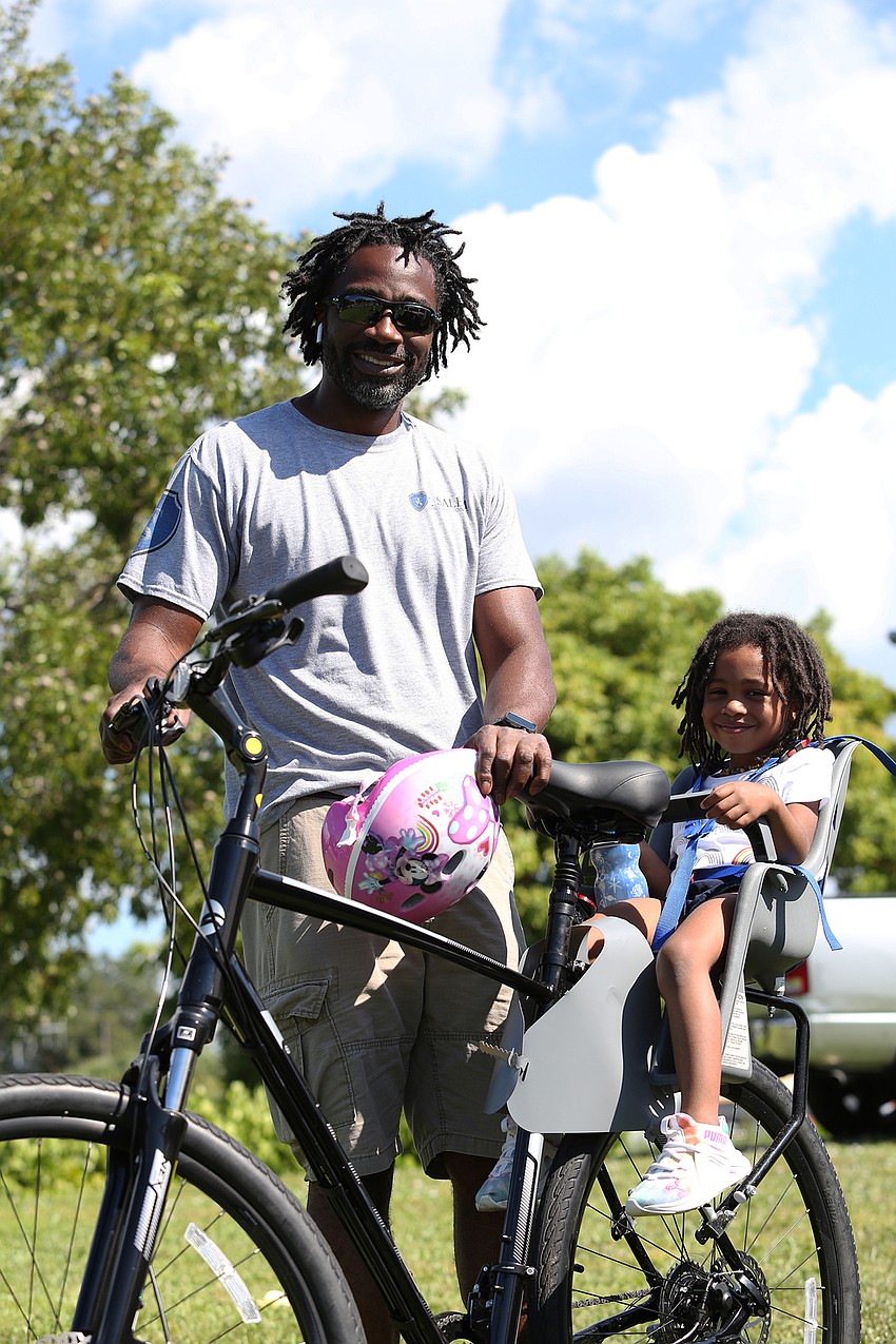 Terrill and Tegan Salem ride a bike around the festival.