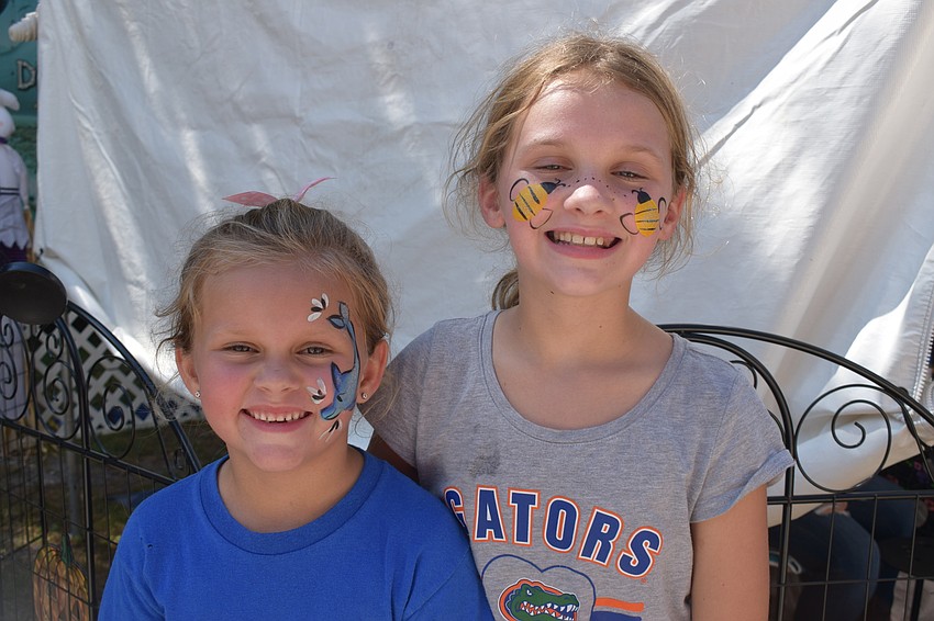 North Port's Lesley Branum, who is 5, gets her face painted with her 9-year-old sister, Adalynn Branum.