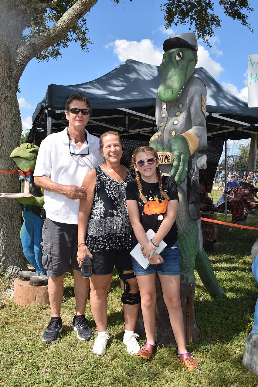 Largo's David Goudy, Debbie Goudy and 13-year-old Josalynn Goudy take a photo by a gator at the Pumpkin Festival. 