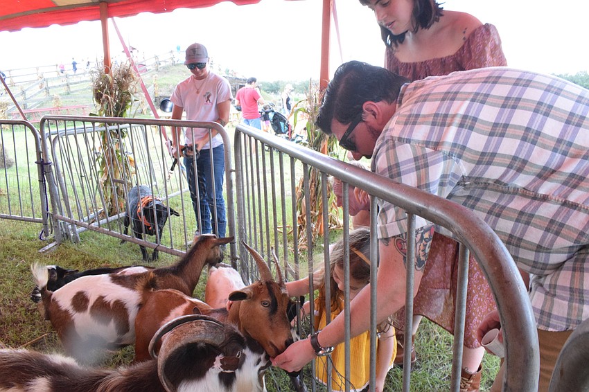 Tampa's Shannon Wells feeds goats with her 2-year-old daughter, Eden Wells, and husband, Jay Wells. 