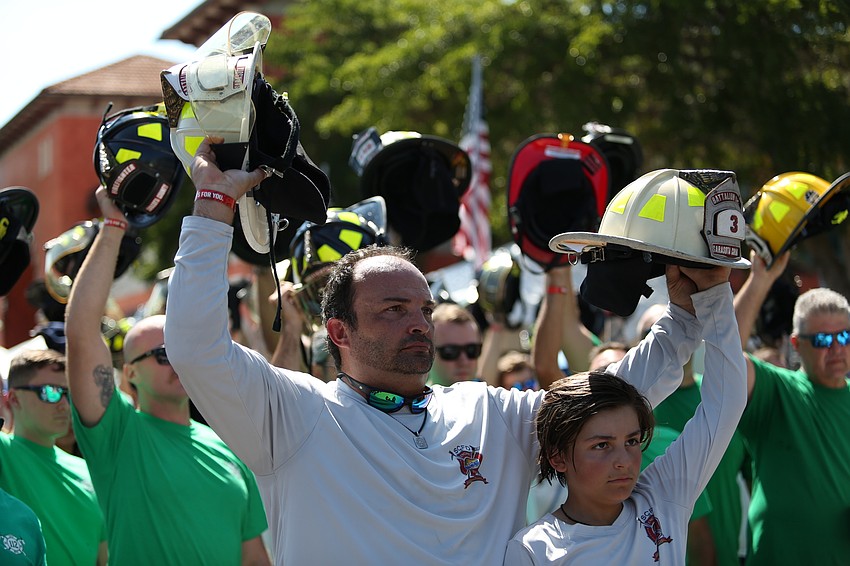 James and Dominic Mattera raise their helmets in support.