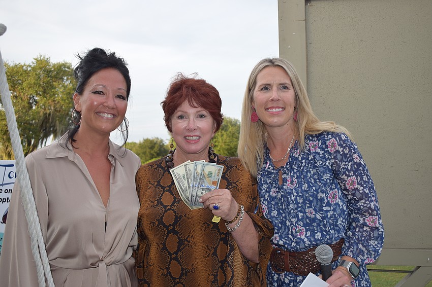 Humane Society at Lakewood Ranch board members Rebekah Boudrie and Angela Carlson accept a $500 donation from Gwen McKenna (center), who won the $500 in the helicopter ball drop.