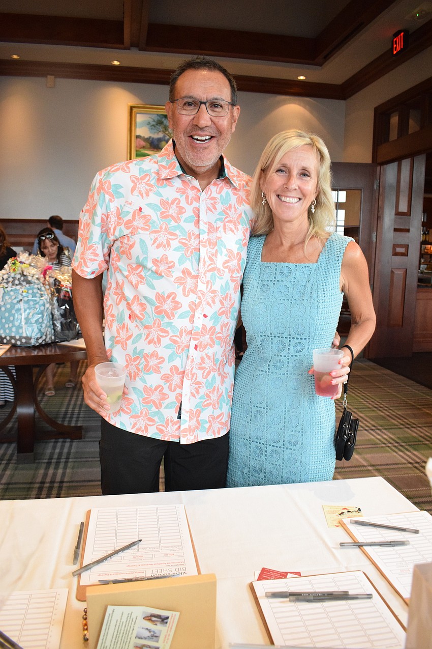 Lakewood Ranch's Peter Herrera and Bonnie Brooks look at what's available in the silent auction.