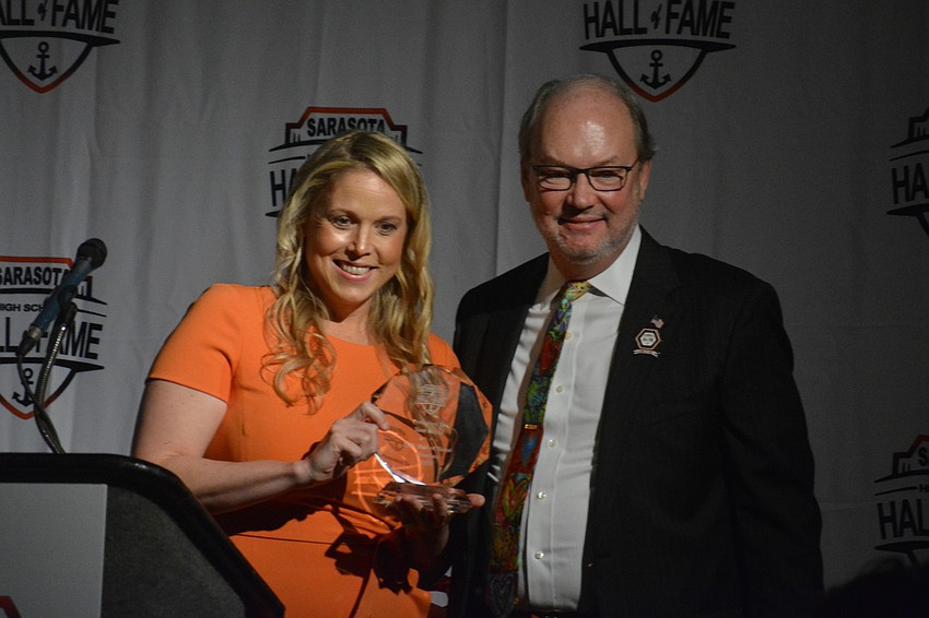 Jeana Schmidt presents Tim Koski with the Eddie Howell Award of Excellence for Koski's philanthropic efforts in the community.