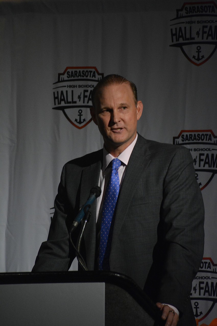 Matt Drews shares a message from Hall of Fame inductee Jane Lutz, who could not attend the event in person. Lutz taught English and journalism at Sarasota High for 35 years.