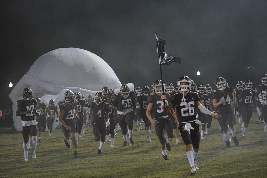Senior Andrew Nordland (26) leads the Pirates onto the field.