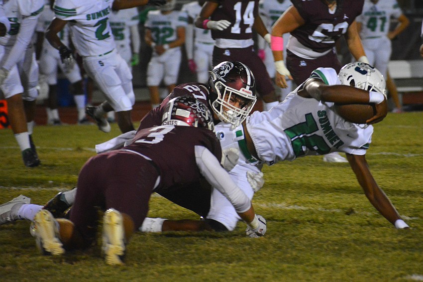 Junior linebacker Aidan Dangler (3) and senior Dawson Thompson (27) take down Sumner quarterback Greg Smith (12).