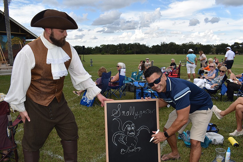 Bill Sablan of Panther Ridge (right) puts the finishing touches on a drawing that would be used in the pre-show entertainment on Saturday in Lakewood Ranch.