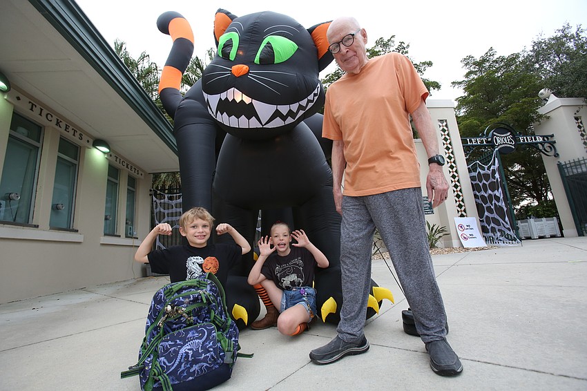 Cash, Trinity and John Stevenson pose with a large black cat.