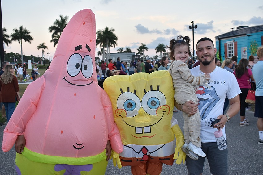 Kevin and Kinley Acevedo (right) of Sarasota mug with SpongeBob SquarePants at Tuesday's Trick-or-Treat by the Lake at Nathan Benderson Park.