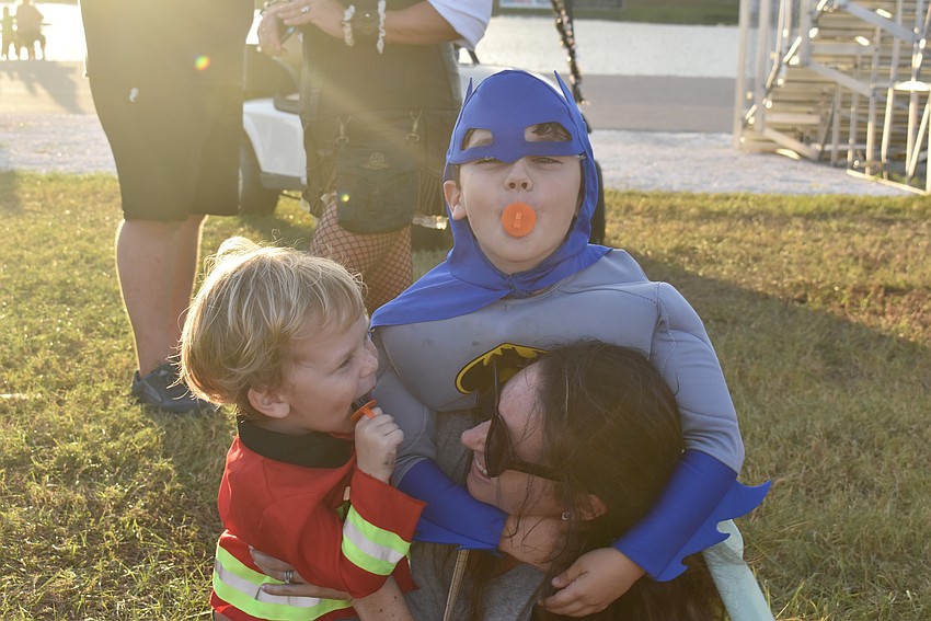 Hayden Grubb (left) and Hunter Grubb (top) ambush Lauren Grubb of Bradenton for a hug at Tuesday night's Trick-or-Treat on the Lake.