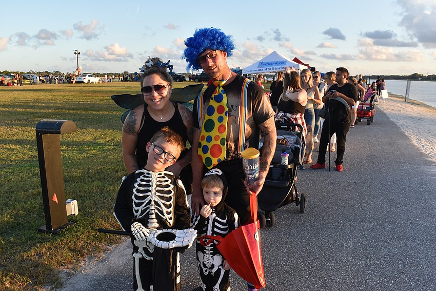 Emily (left), Jason, Easton and Jason Evans stand at the front of a long line of trick-or-treaters on Tuesday night at Nathan Benderson Park.