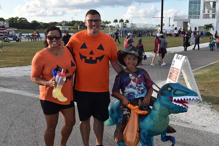 Natalia, Robert and Nelson Harris of Sarasota take their first load of candy to their car at Tuesday night's Trick-or-Treat on the Lake.