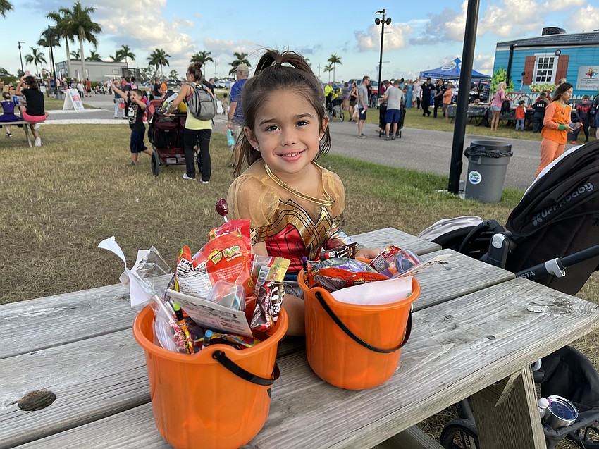 Eliana Ruck of Lakewood Ranch examines her haul of candy at Tuesday night's Trick-or-Treat on the Lake at Nathan Benderson Park. Ruck was one of thousands of children to take advantage of the early start to Halloween weekend.
