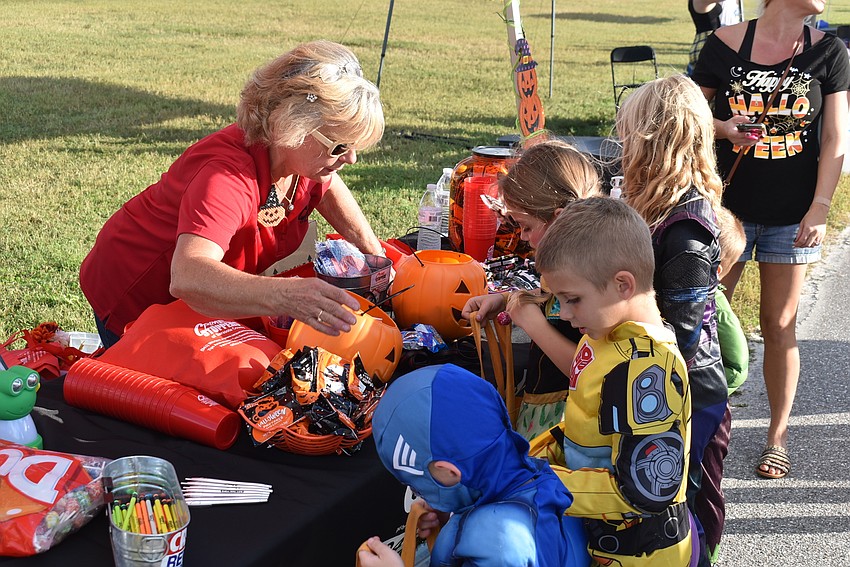 A group of trick-or-treaters jockey for candy at one of the several tables set up by area businesses at Tuesday's Trick-or-Treat on the Lake.