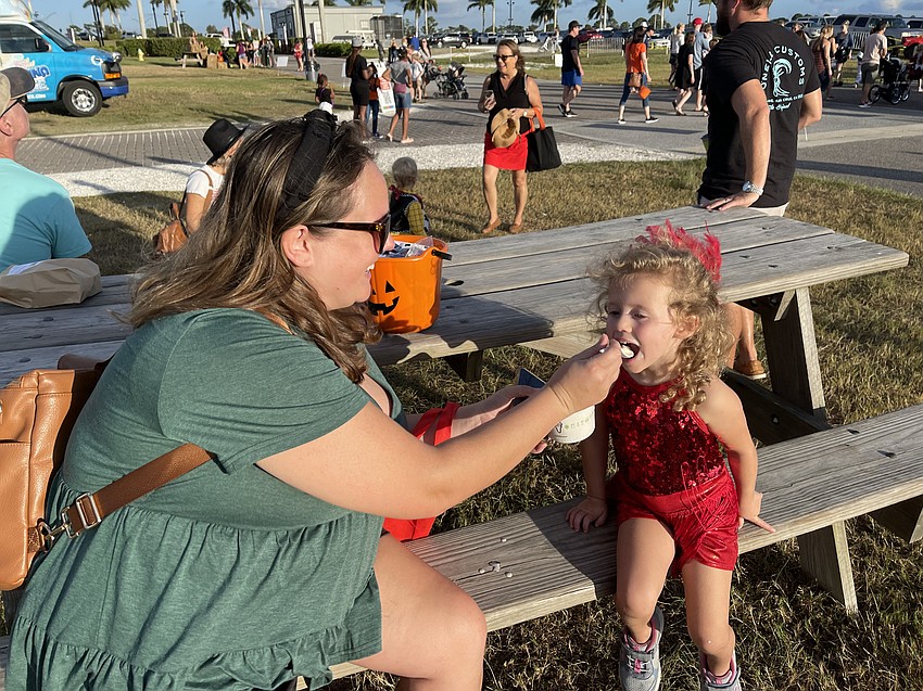 Mary Anne Copeland or Parrish feeds Amelia Copeland a spoon full of ice cream at Tuesday night's Trick-or-Treat on the Lake.