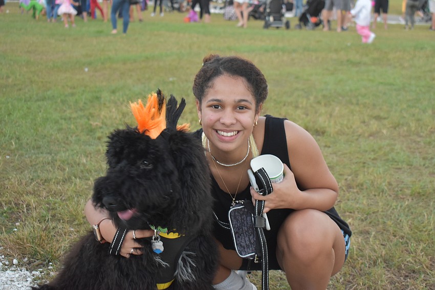Elisa Uzcategui and Tequeno the dog stroll amongst the  thousands trick-or-treaters Tuesday night at Nathan Benderson Park.