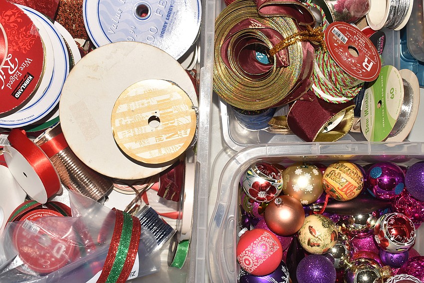 Boxes of extra ribbons and ornaments stand ready to be added to trees.