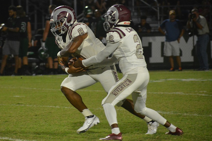 Rams senior Jay'den Birch gets a handoff from junior Will Carter Jr.