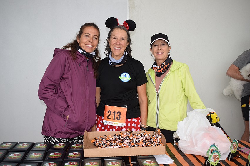 Andrea Rutsky, the president of the Lakewood Ranch Running Club, Donna Marino, the club's vice president, and Kathy Glubiak, a member of the club, prepare to hand out awards.