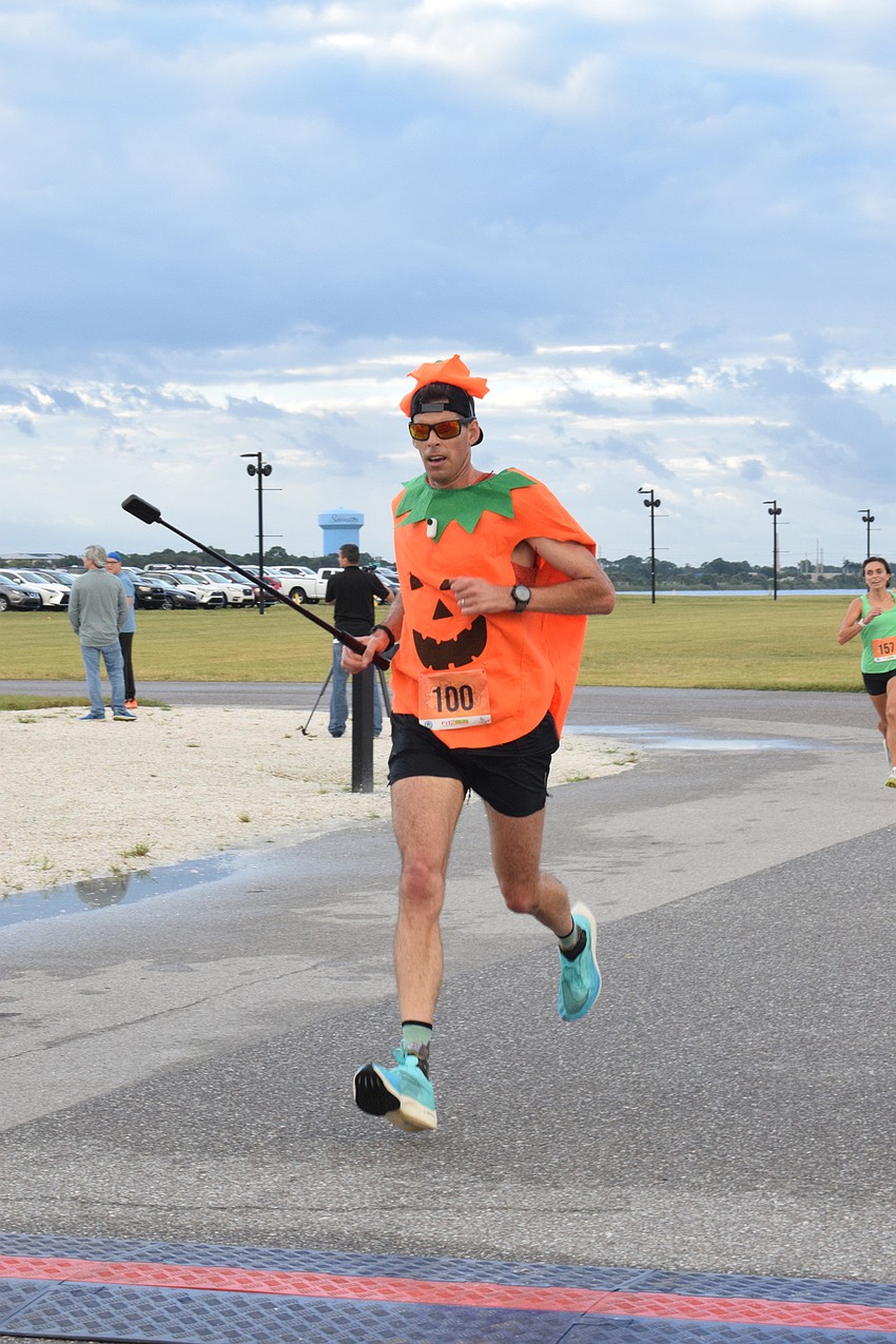 Dressed as a pumpkin, Lakewood Ranch's Matt Bertrand crosses the finish line. Bertrand has participated in six previous Boo Runs.