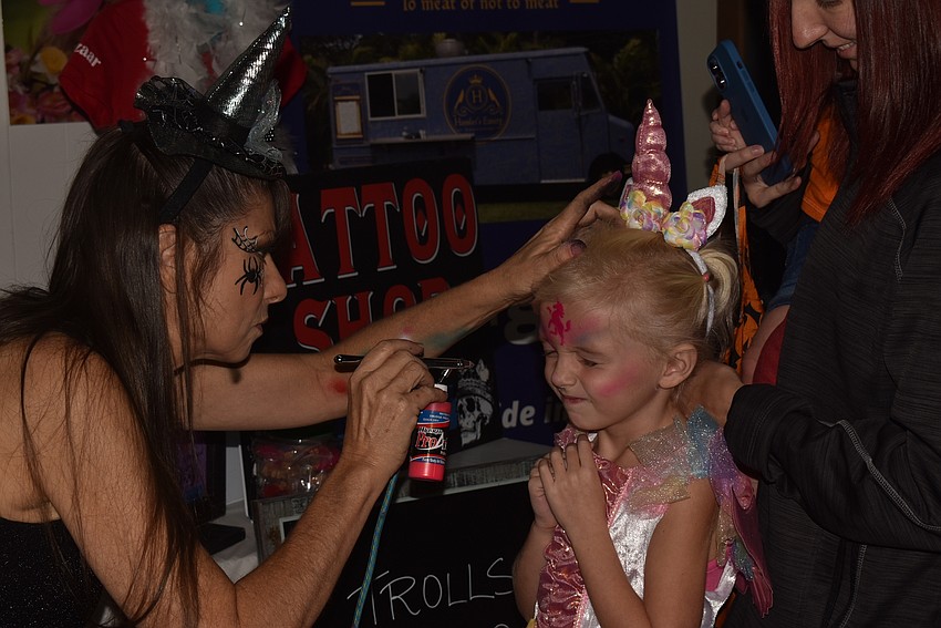 Suzy Kalin airbrushes Hazel Richter's tattoo.