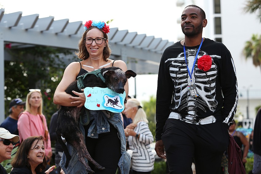 Chelsea Jack and Regi Bastian carry their dog Piko to the front.