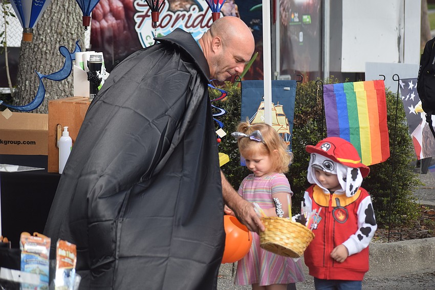 Dean Miller, who is a vendor with his Pesky Bug Away, hands out candy to Lakewood Ranch 3-year-old Charlotte Maliwacki and 3-year-old Dylan Albright.