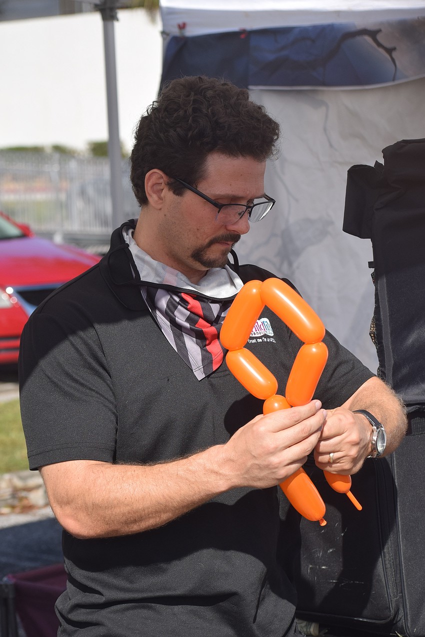 A line of children waiting to get balloon art made by Parrish's Randy Babb.