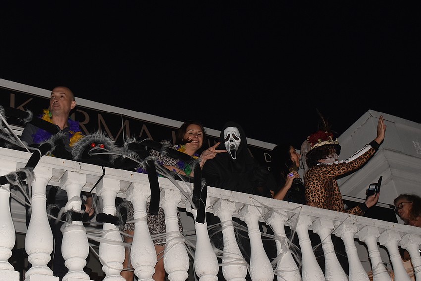Above Settimi's Gelato, folks in costumes waved to trick-or-treaters below.