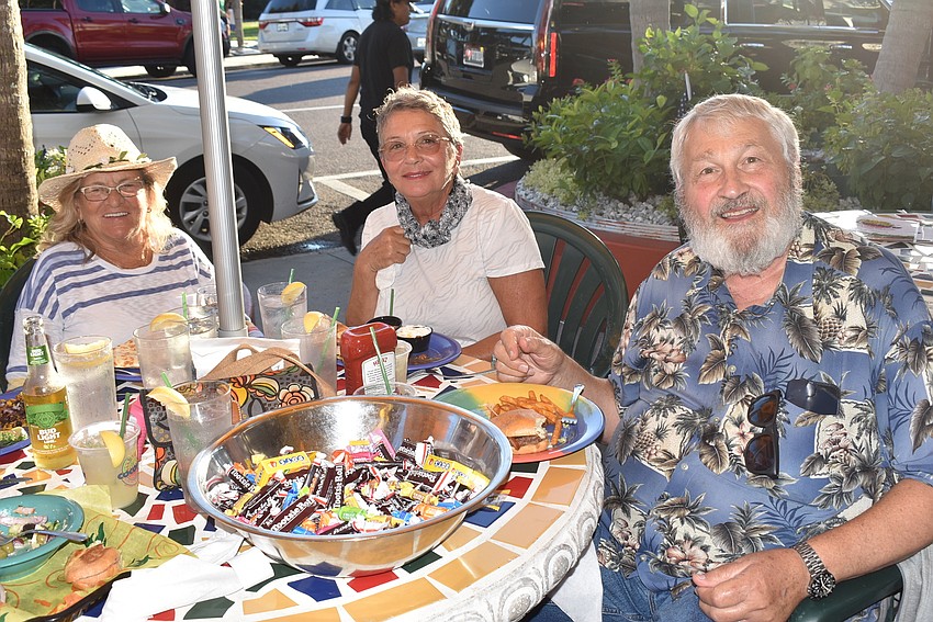 Sue Pilotti, Sharon Eckhart and John McGee gave out candy while eating at Cha Cha Coconuts.