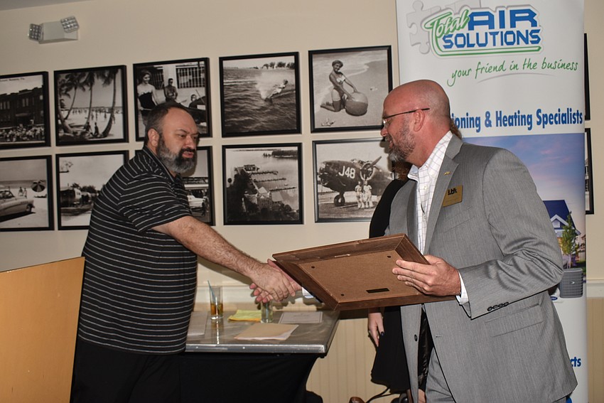 Ramin Mesghali shakes hands with Willie McLaughlin.