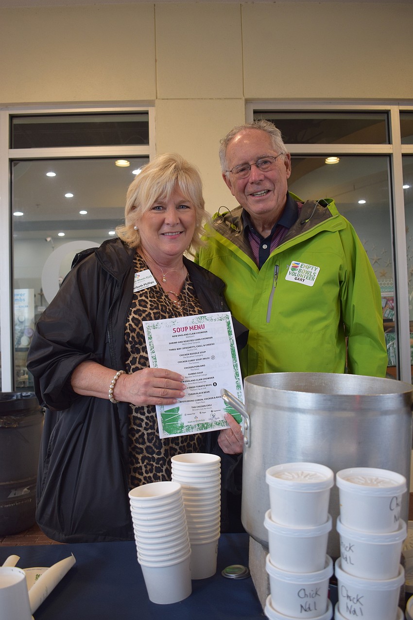 Maribeth Phillips, the president and CEO of Meals on Wheels Plus of Manatee, and Country Club East's Gary Corson serve soup to people who come through the drive-thru of Empty Bowls.
