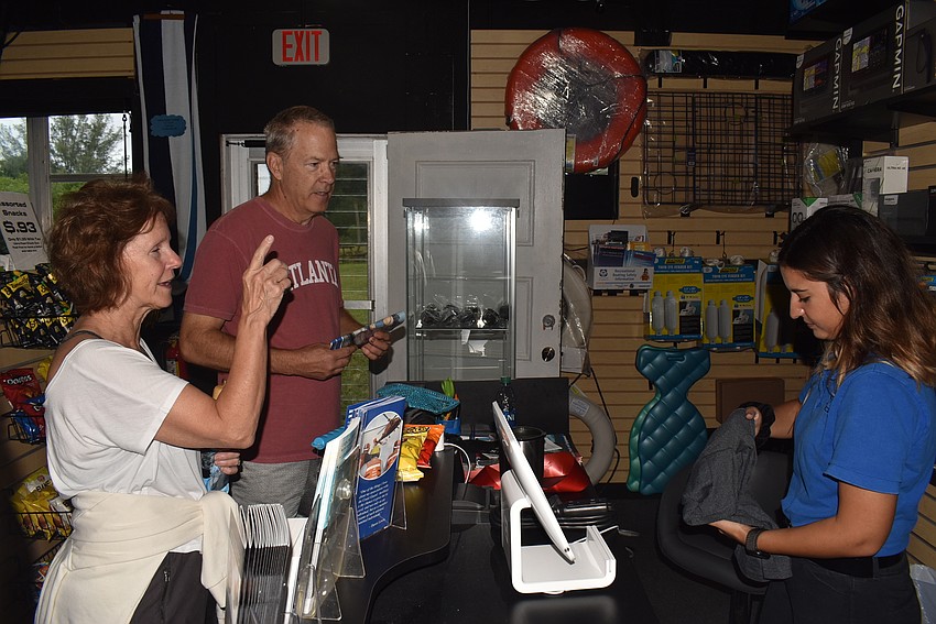 Emily Pacula, right, makes a sale to Tom and Katie Gridley.