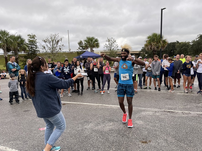 Alvin Ducre (center) of Palmetto celebrates his first place finish in the men's 25-29 age division in the Fort Hamer Bridge Run.