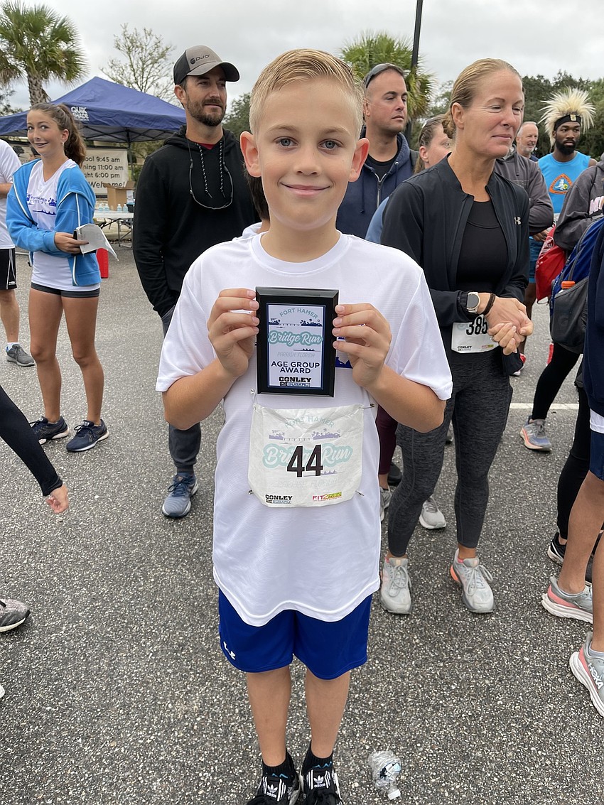Ellenton's Alexander Wolanin, 9, was all smiles after taking first place in the male ages 1-9 age group in the Fort Hamer Bridge Run on Saturday.