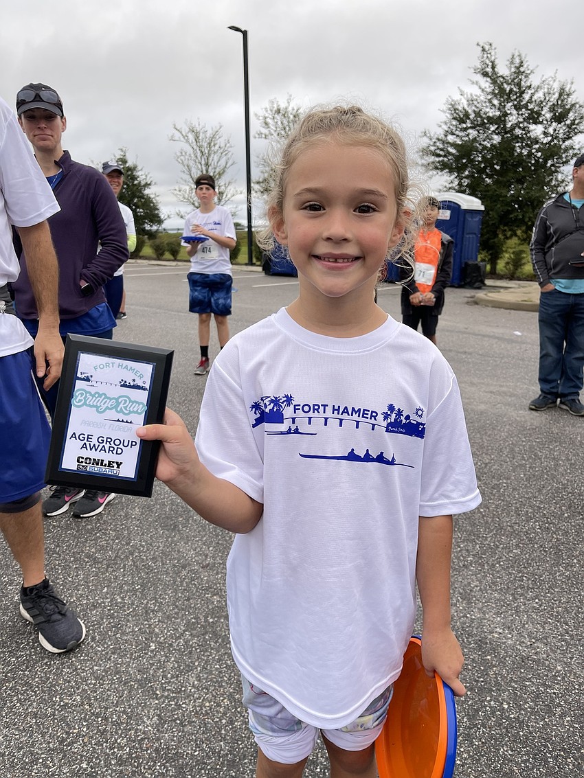 Julia Fellin, 6, of Bradenton took home some frisbees and a first place trophy in the female 1-9 age group from Saturday's Fort Hamer Bridge Run.