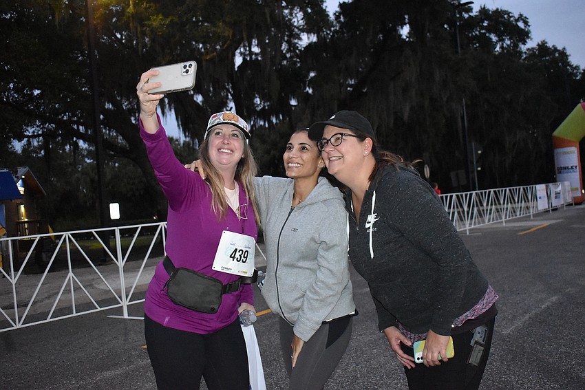Priscilla Doiron, Sandra Arango and Astryd Ghysbrecht, all of Lakewood Ranch, grab a selfie prior to the start of Saturday's Fort Hamer Bridge Run.