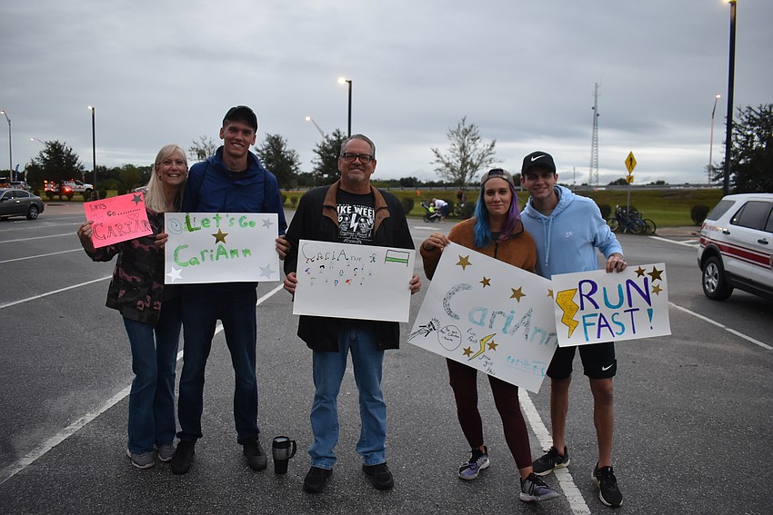 Robin Evans, Robbie Evans, Earl Evans, Lindsay Evans and T.J. Smith all wave signs of encouragement for runner CariAnn Evans at Saturday's Fort Hamer Bridge Run.