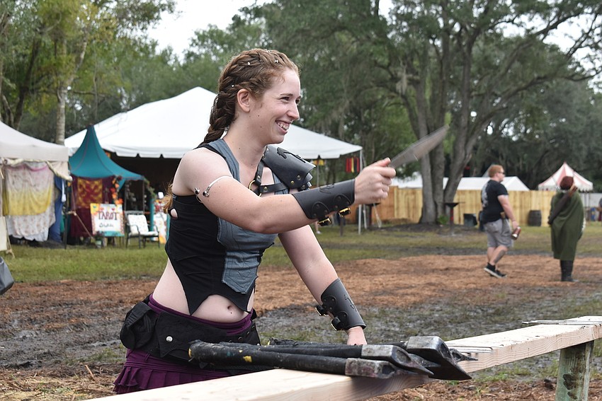 Hannah Lipsey of Punta Gorda throws knives and axes at the Sarasota Medieval Fair. Lipsey had better luck with the knives, with three of them sticking to the board.