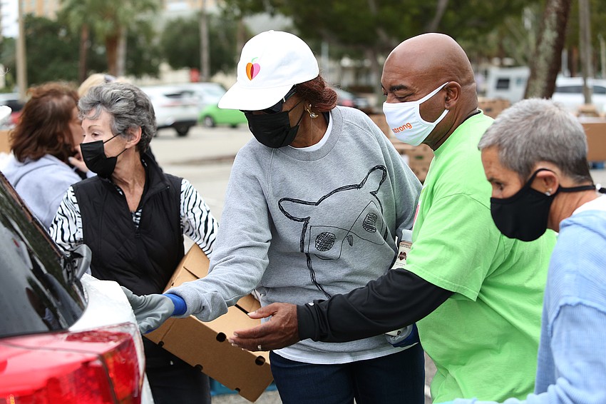 Volunteers deliver food to each car.