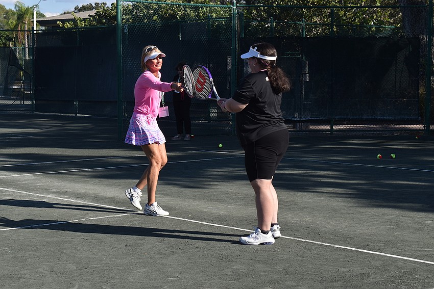 Brenda Terihay taps rackets with Bryanna Schmidt after a successful point.