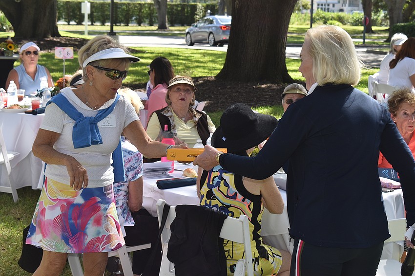 Bunny Skirboll won a dozen golfballs, which Noreen Ackerman handed to her.
