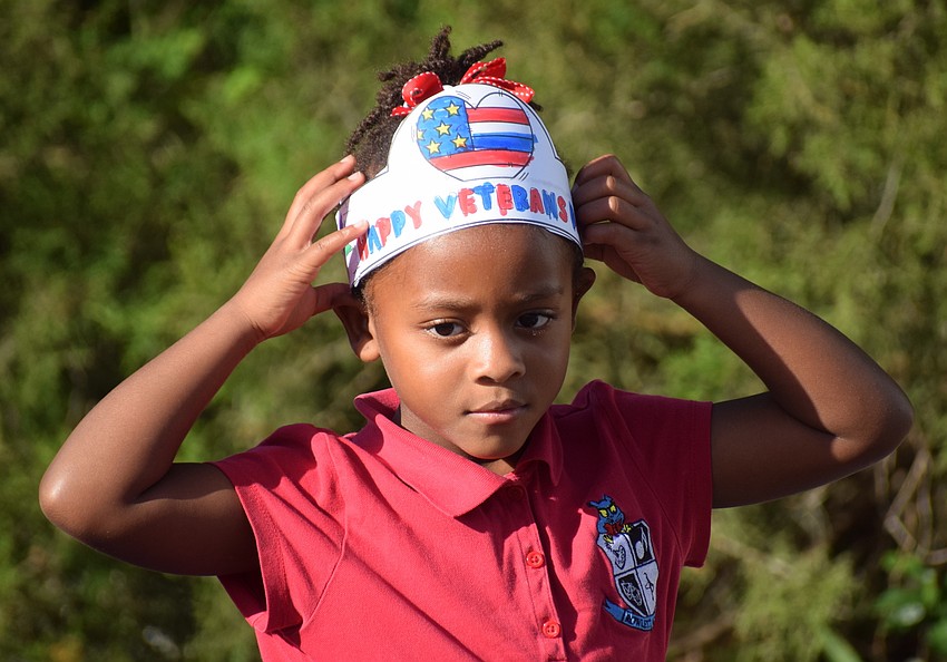 First grader Zoe Freeman shows off her veterans ceremony hat while watching the show.